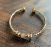 Adjustable bracelet with golden charms